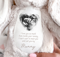 A white plush teddy bear with a personalized photo print of a baby ultrasound scan and a message that reads 'I love you so much from inside your tummy, I can't wait to meet you and call you my Mummy.'.