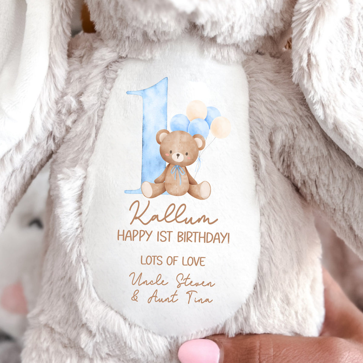 A soft toy brown beige bunny with Happy 1st Birthday message and teddy bear with balloons