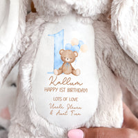 A soft toy brown beige bunny with Happy 1st Birthday message and teddy bear with balloons