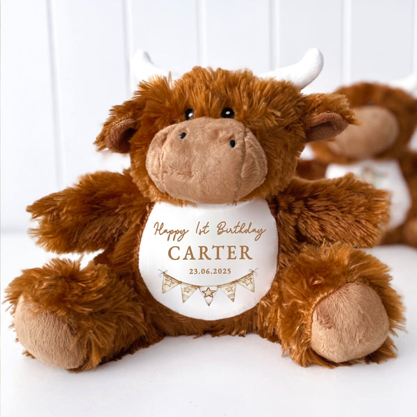A highland cow soft toy teddy with a Happy Birthday message printed on the white belly, cowboy theme.